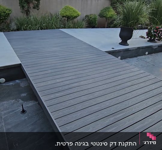 גשר עץ בגינה עם צמחייה מסביב